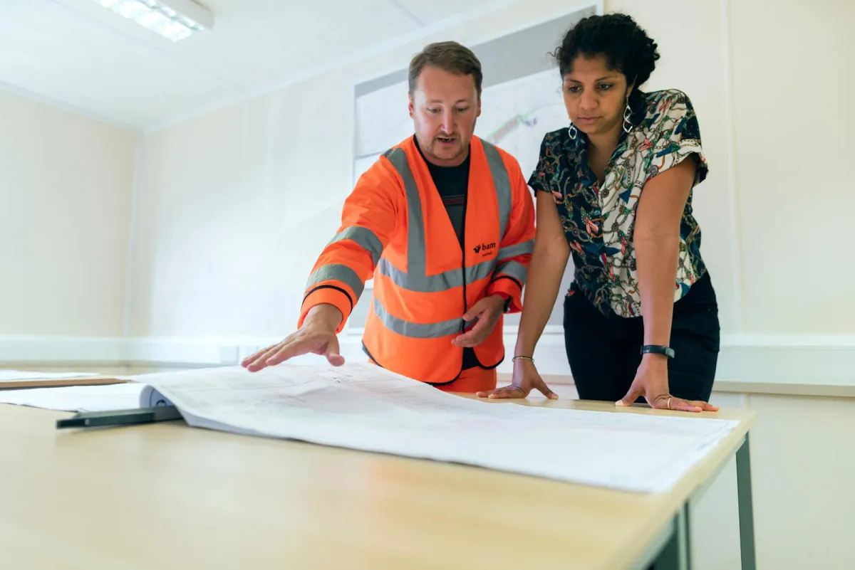 Construction professional reviewing software options on tablet at UK building site